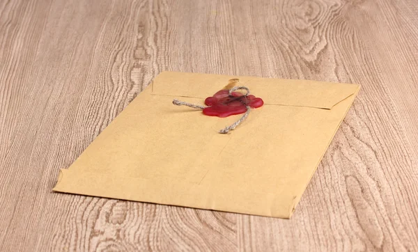Envelope with sealing wax on wooden background — Stock Photo, Image