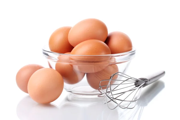 Metallbesen zum Aufschlagen von Eiern und braunen Eiern in einer Schüssel isoliert auf weiß — Stockfoto