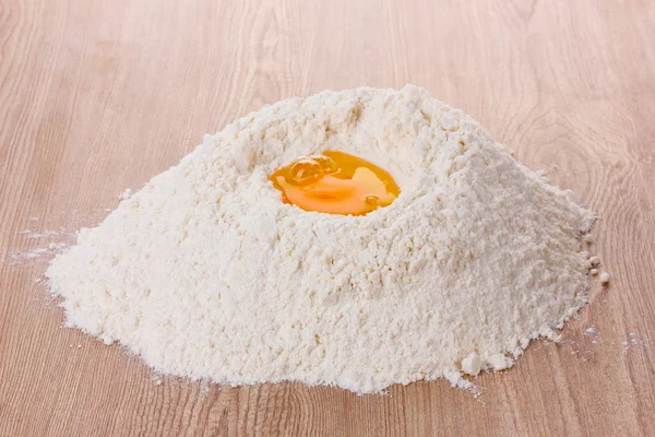 stock image Egg in flour on wooden table