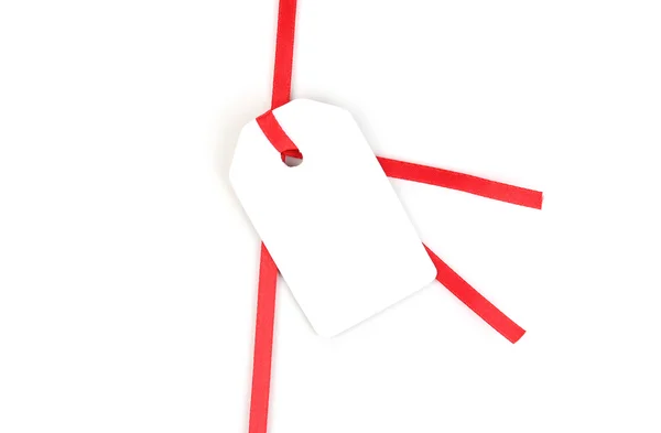 Etiqueta de presente em branco na fita de cetim vermelho isolado no branco — Fotografia de Stock