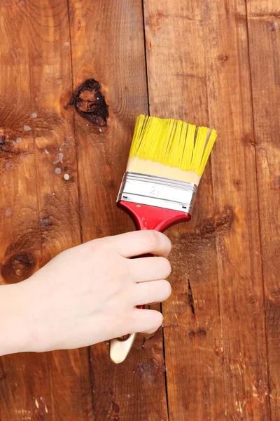 Окраска деревянного забора желтой краской — стоковое фото