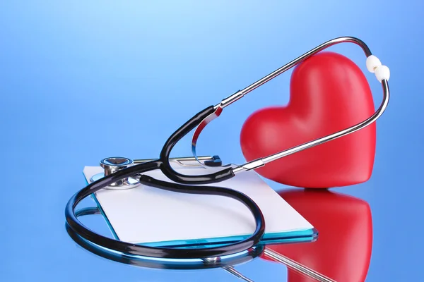 Orvosi sztetoszkóppal vágólap és a szív, a kék háttér — Stock Fotó