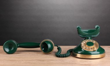 Retro phone on wooden table on grey background clipart