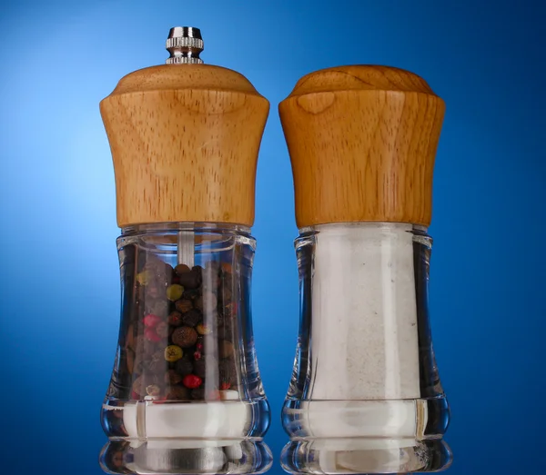 Salt and pepper mills on blue — Stock Photo, Image
