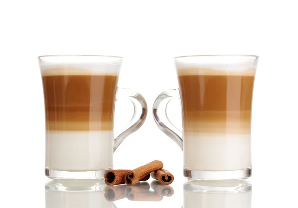 Café con leche fragante en copas de vidrio y canela aislada en blanco —  Fotos de Stock