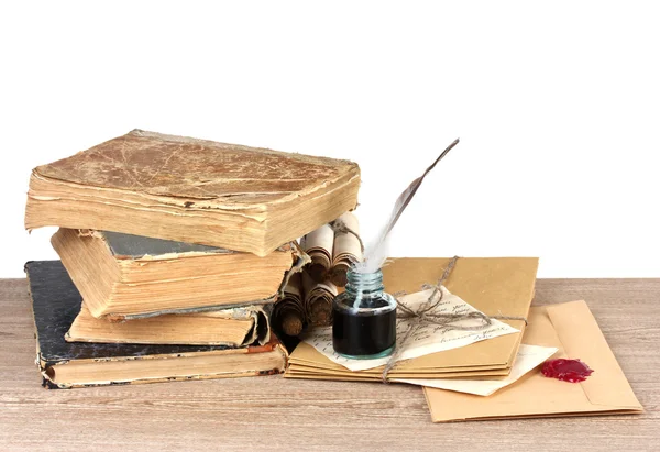 stock image Old books, scrolls, feather pen and inkwell on wooden table on grey backgro
