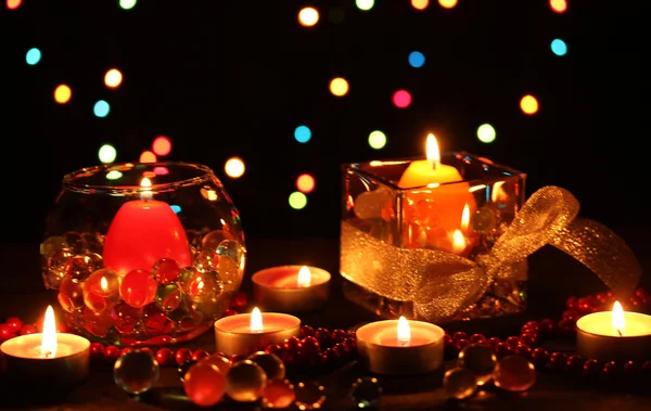 Maravillosa composición de velas sobre mesa de madera sobre fondo brillante —  Fotos de Stock