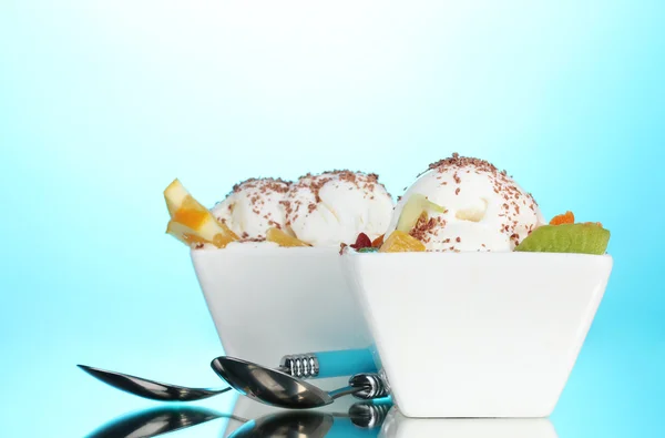 Смачне ванільне морозиво з шоколадом і фруктами в мисках і ложках о — стокове фото