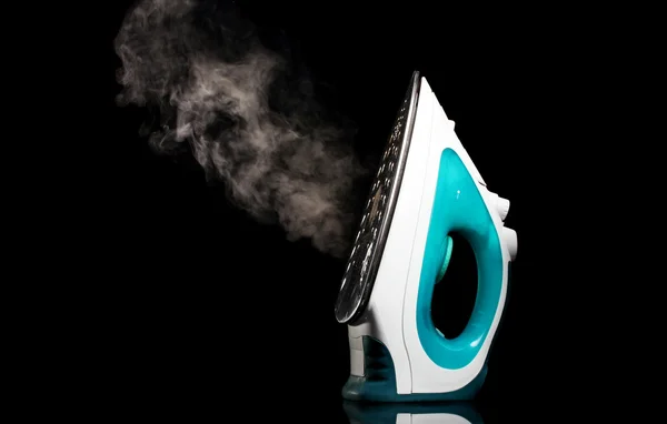 Electric iron with steam on black — Stock Photo, Image
