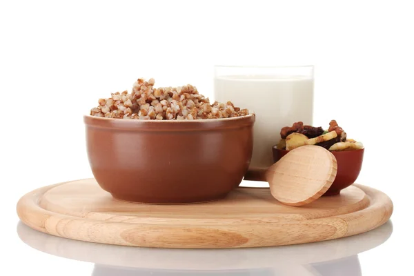 Grano saraceno bollito in una ciotola marrone un bicchiere di latte su una tavola di legno isolato — Foto Stock