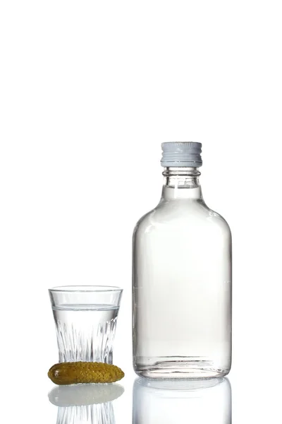 Бутылка водки и бокал вина с огурцом изолированы на белом — стоковое фото