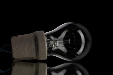 Light bulb in cartridge on black background clipart