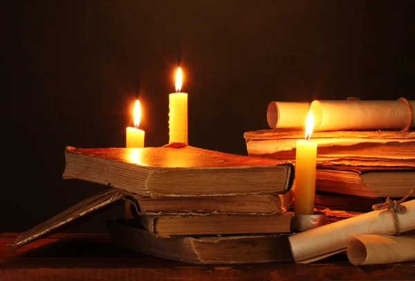 Hromadu starých knih s svíčku a posun ve tmě — Stock fotografie