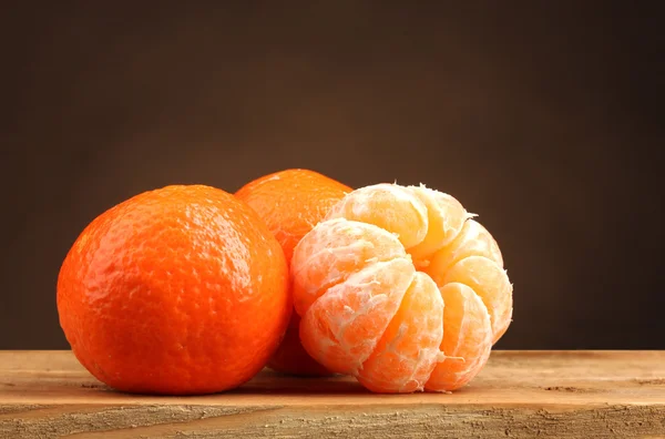 Mandarinen auf Holztisch auf braunem Hintergrund — Stockfoto