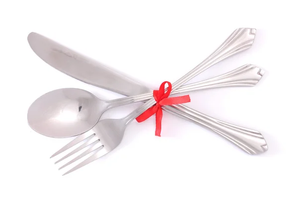 Silver widelec i łyżka, nóż, związany z czerwoną wstążką na białym tle — Zdjęcie stockowe