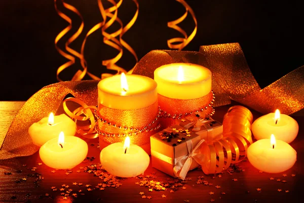 Hermosas velas, regalos y decoración en mesa de madera sobre fondo marrón —  Fotos de Stock