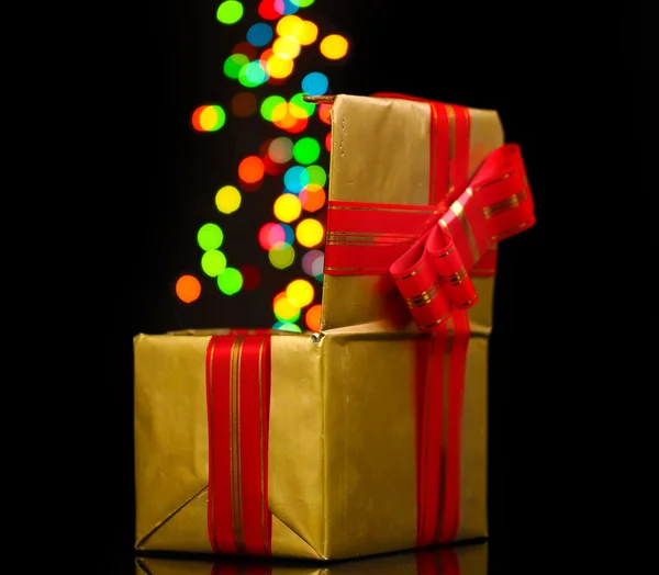 Öppna gyllene presentförpackning med bokeh bakgrund på svart — Stockfoto