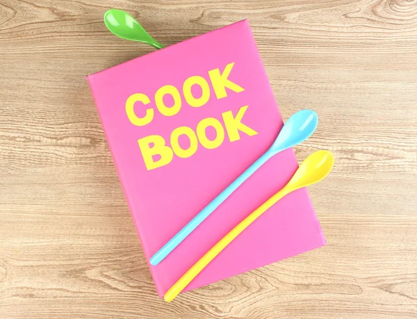Libro de cocina y utensilios de cocina sobre fondo de madera — Foto de Stock