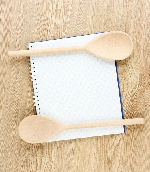 Libro de cocina abierto y utensilios de cocina sobre fondo de madera —  Fotos de Stock