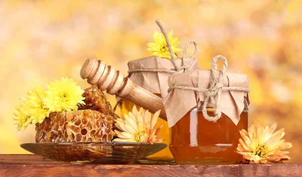 2 つの jar の蜂蜜、ハニカム、黄色の backgro にテーブルの上の木 drizzler — ストック写真