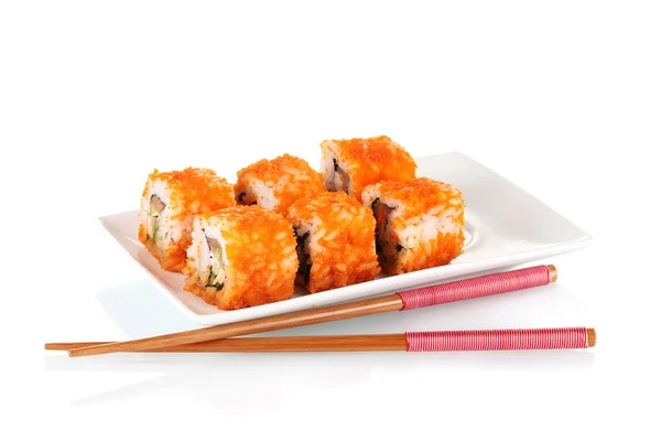 Pyszne sushi na płytkę i pałeczki na białym tle — Zdjęcie stockowe