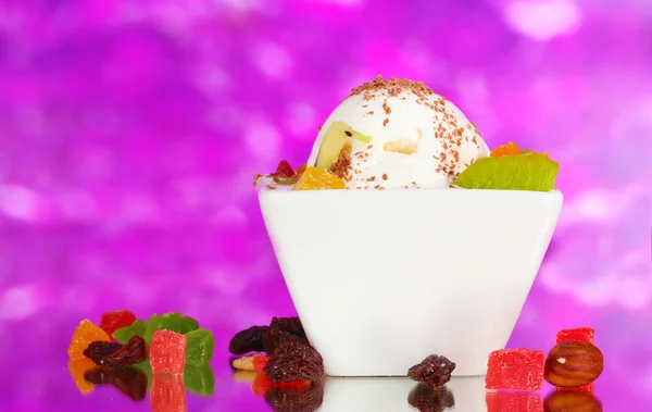 Вкусное ванильное мороженое с шоколадом и фруктами в миске на фиолетовом пакете — стоковое фото