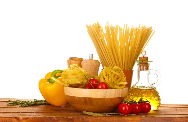 Espaguete, macarrão na tigela, jarra de óleo e legumes em isola de mesa de madeira — Fotografia de Stock