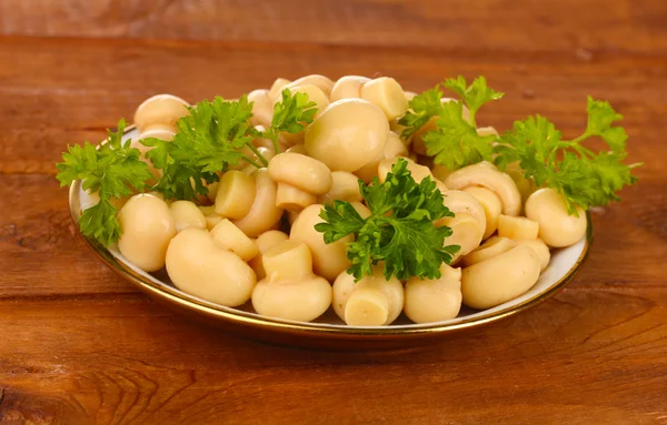 Nakládané houby v talíř na dřevěný stůl — Stock fotografie