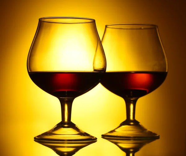 Deux verres de cognac sur fond jaune — Photo