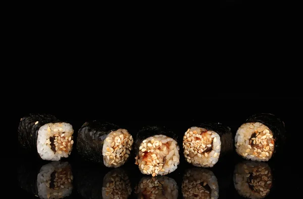 Deliciosos rollos en línea aislados en negro —  Fotos de Stock