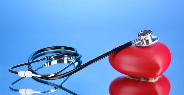 Lékařský stetoskop a srdce na modrém pozadí — Stock fotografie