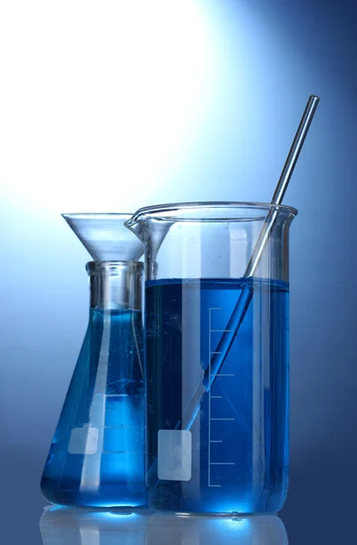 Tubes à essai avec liquide bleu sur fond bleu — Photo