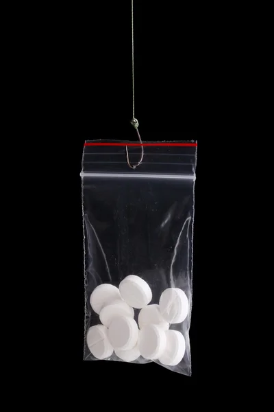Tablety na udici izolované na černém pozadí — Stock fotografie