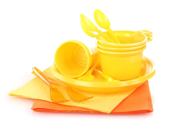 Bright yellow plastic tableware and napkins isolated on white — Stock Photo, Image