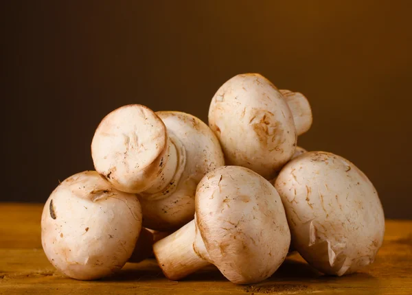Champignons Pilze im Korb auf Holztisch auf braunem Hintergrund — Stockfoto
