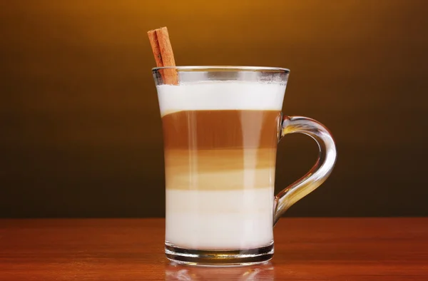 Duftender Kappuccino-Latte in Glasschale und Zimt auf Holztisch auf Braue — Stockfoto