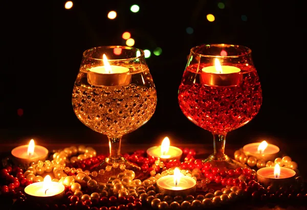 Composição surpreendente de velas e óculos na mesa de madeira em backgr brilhante — Fotografia de Stock