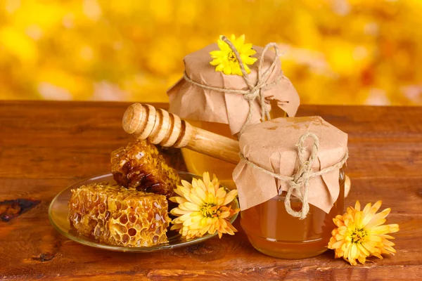 꿀, 넓어짐, 노란색 backgro 테이블에 나무 drizzler의 두 항아리 — 스톡 사진