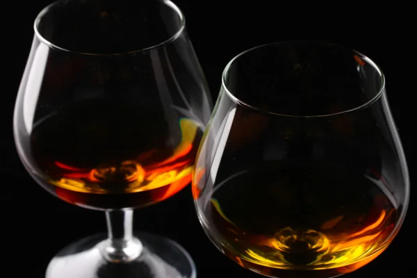 Two glasses of cognac on black background — Stock Photo, Image