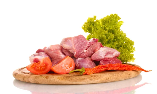 Кусочки сырого мяса и овощей на деревянной доске изолированы на белом — стоковое фото