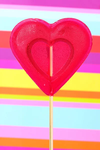 縞模様の背景に赤の心ロリポップ — ストック写真