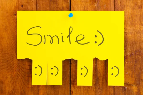 Barevná reklama úsměv na dřevěné pozadí — Stock fotografie