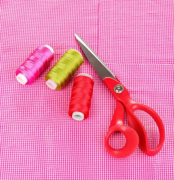 Scissors and bright threads on fabric isolated on white — Stock Photo, Image