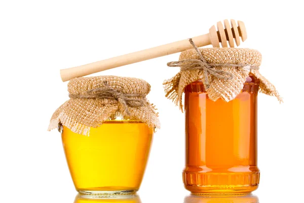 Süßer Honig in Gläsern mit Nieselregen isoliert auf weiß — Stockfoto