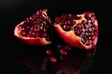 Ripe pomegranate fruit on black background clipart