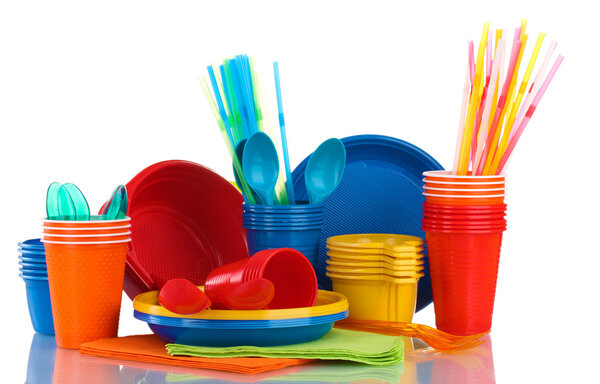 Bright plastic tableware and napkins isolated on white