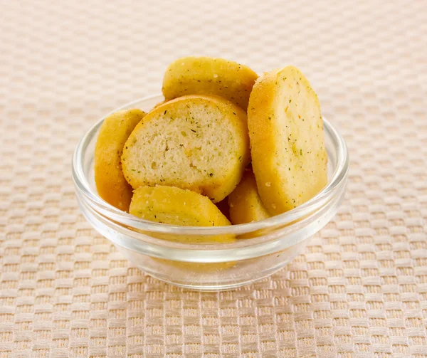 Fette biscottate appetitose in ciotola su tovagliolo beige — Foto Stock