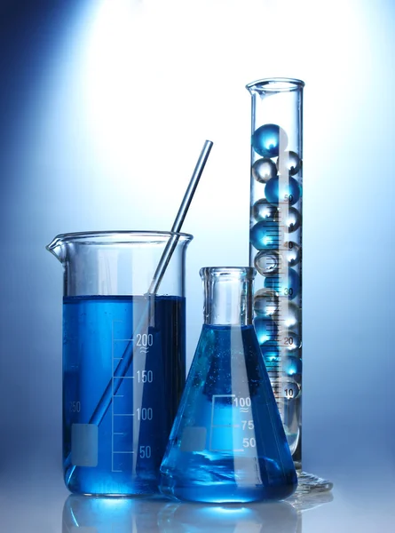 파란색 배경에 파란색 액체와 시험관 — 스톡 사진