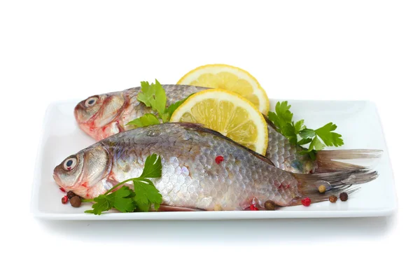 Fresh fishes with lemon and parsley on plate isolated on white — Stock Photo, Image