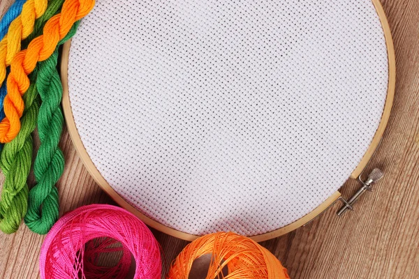 El aro de bordado con tela e hilos de coser brillantes para bordar en la mesa — Foto de Stock